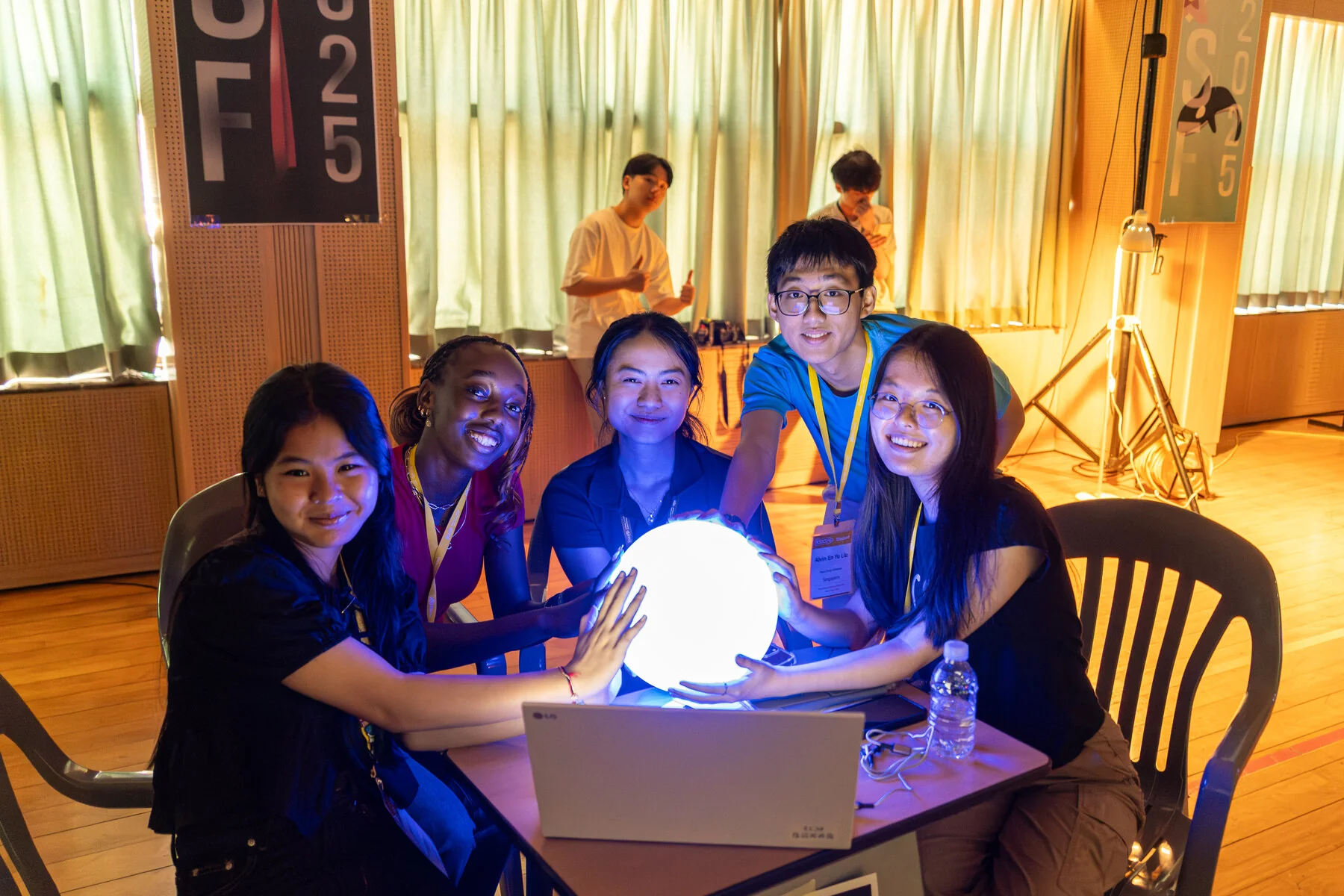 An international team gathered around a glowing sphere at KSASF 2025.